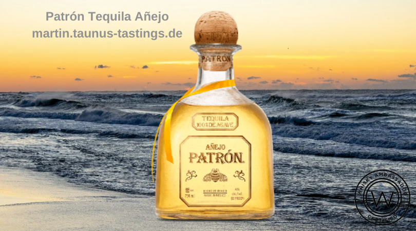 Eine Flasche Patrón Tequila Añejo mit dem Meer im Hintergrund