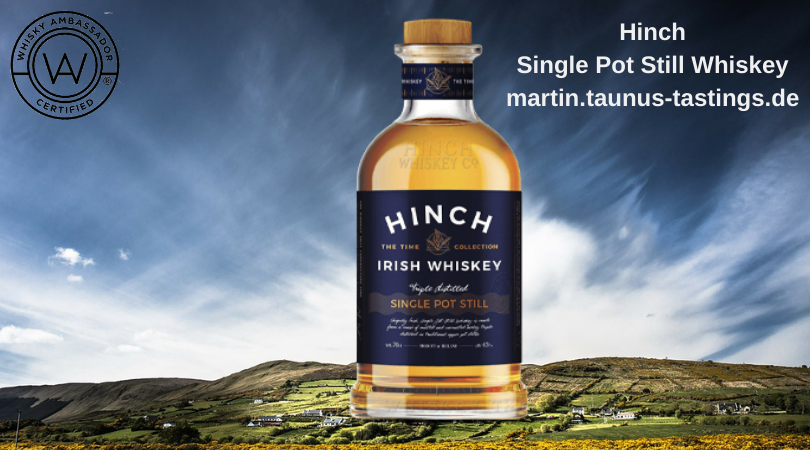 Eine Flasche Hinch Single Pot Still Irish Whiskey, im Hintergrund eine irische Landschaft