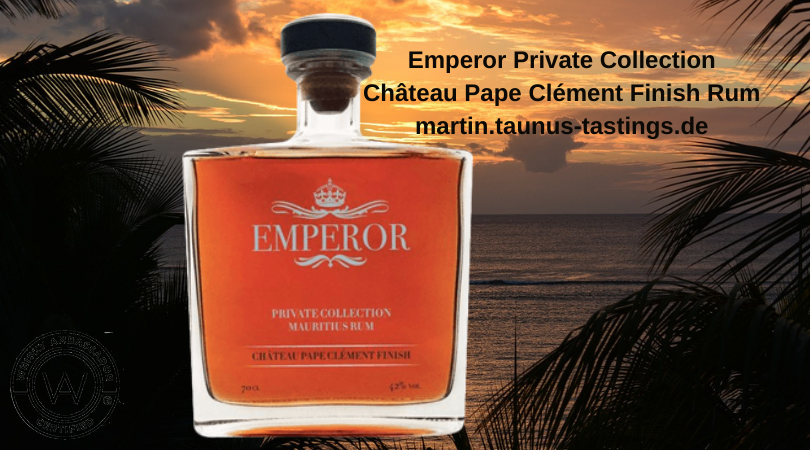 Eine Flasche Emperor Private Collection Château Pape Clément Finish Rum, im Hintergrund ein Sonnenuntergang am Strand von Mauritius