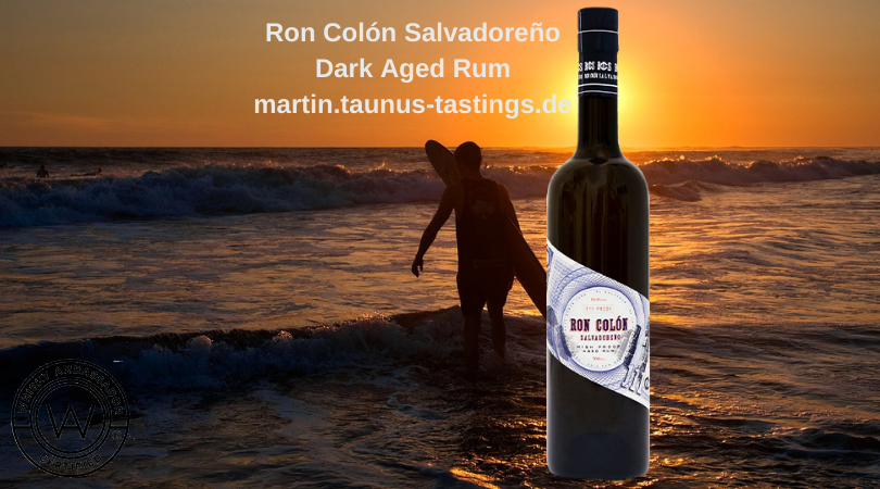 Eine Flasche Ron Colón Salvadoreño Dark Aged Rum, im Hintergrund die Küste und ein Surfer