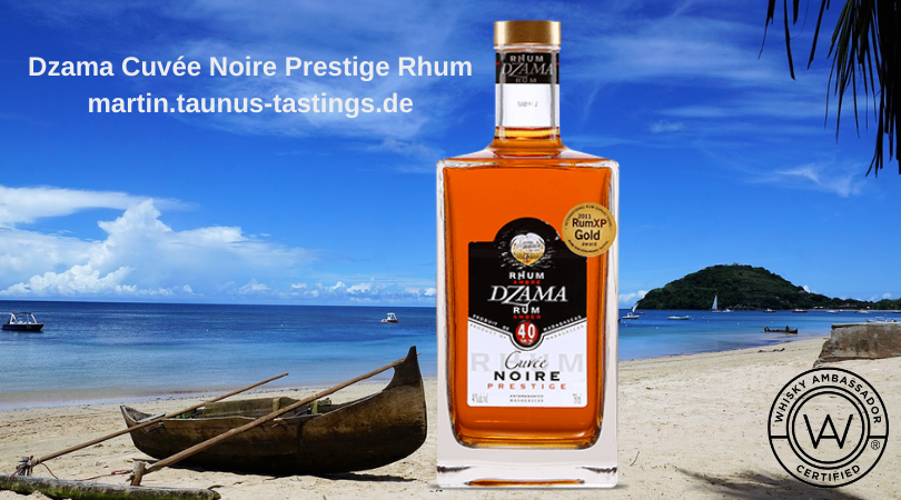 Eine Flasche Dzama Cuvée Noire Prestige Rhum, im Hintergrund ein Strand von Madagascar