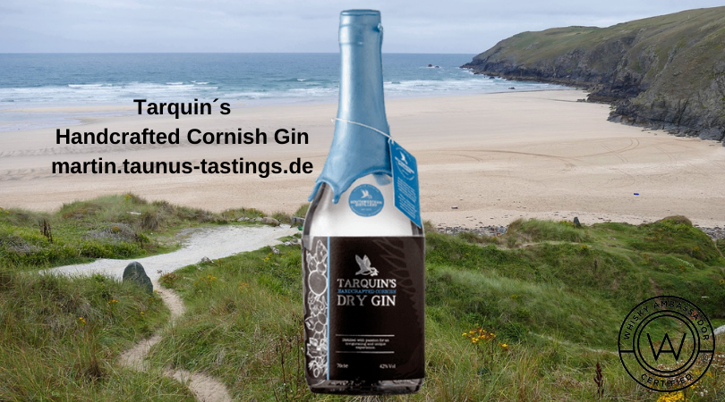 Eine Flasche Targuin´s Handcrafted Cornish Gin, im Hintergrund eine Küste in Cornwall