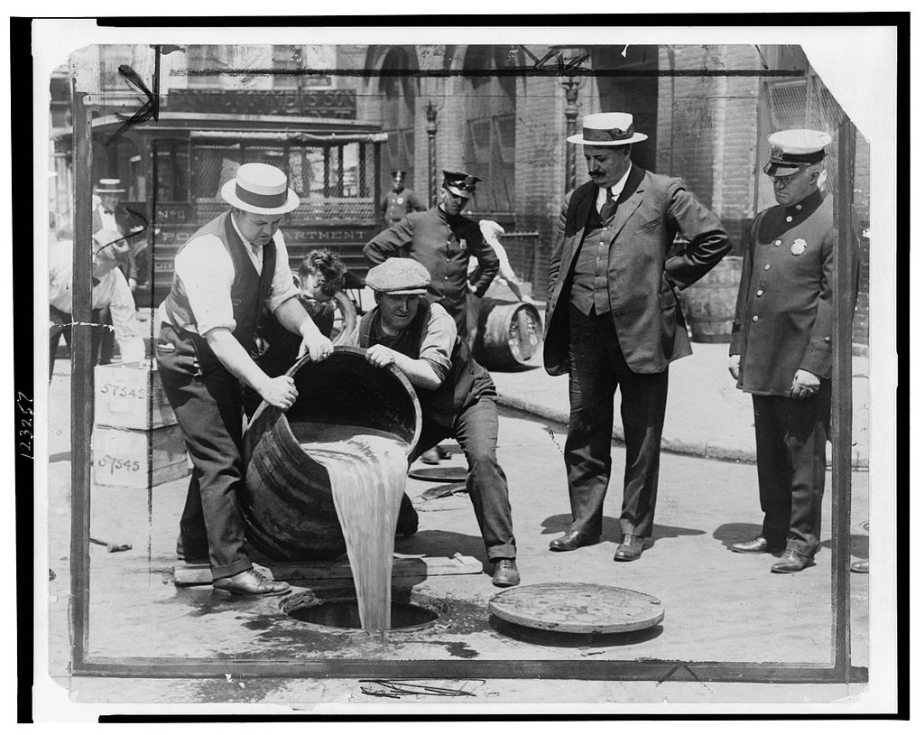 Scotch während der Prohibition - Arbeiter leeren Whisky-Fässer in einen Abfluss