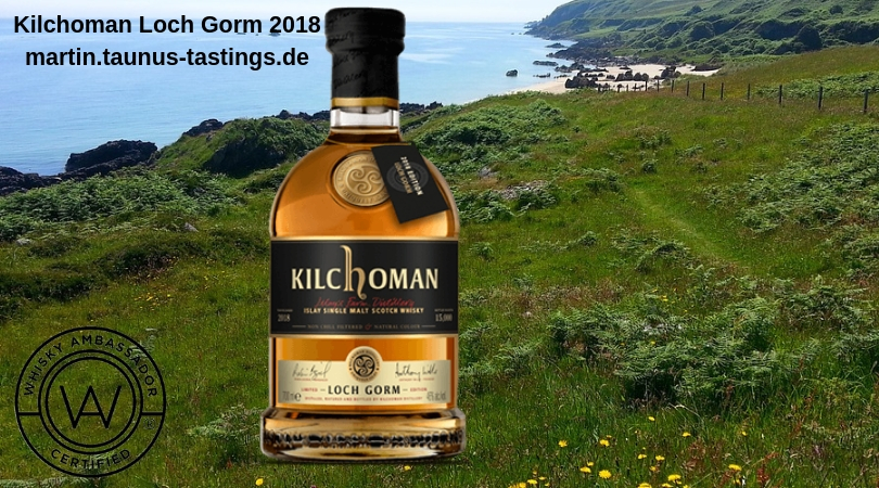 Eine Flasche Kilchoman Loch Gorm 2018, im Hintergrund eine Landschaft auf der Insel Islay in Schottland