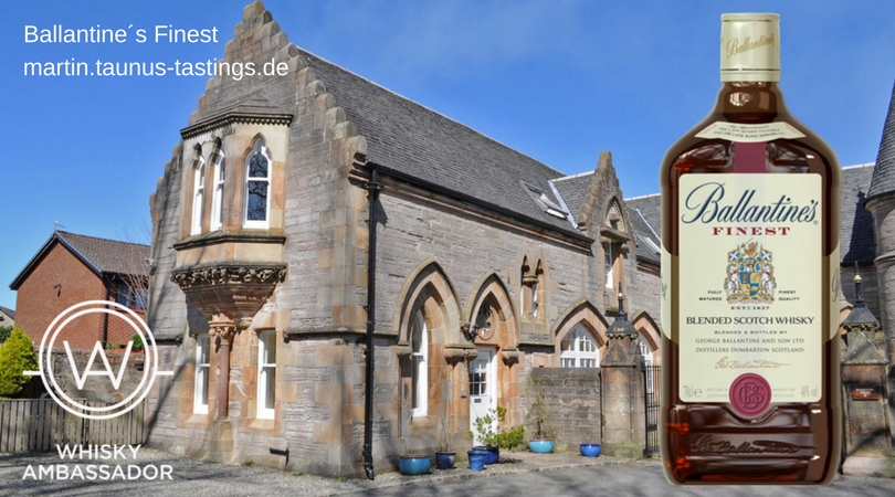 Eine Flasche Ballantines Finest, im Hintergrund ein Landgut in Schottland