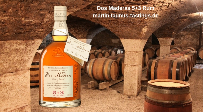 Eine Flasche Dos Maderas 5+3 Rum, im Hintergrund ein Reifekeller in Spanien