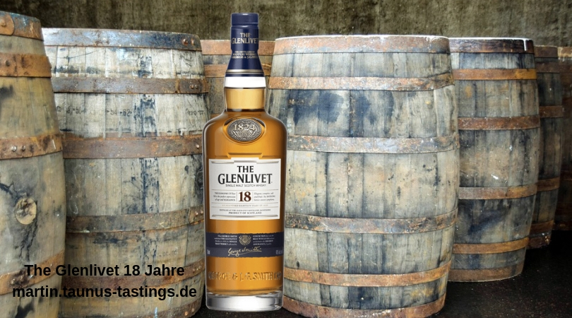 Eine Flasche The Glenlivet 18 Jahre, im Hintergrund Whiskyfässer