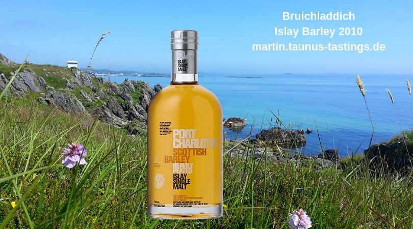 Eine Flasche Bruichladdich Islay Barley 2010, im Hintergrund die Küste der Isle of Islay