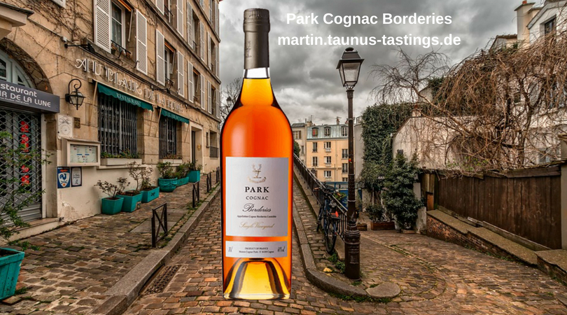 Eine Flasche Park Cognac Borderies, im Hintergrund eine Stadt in Frankreich