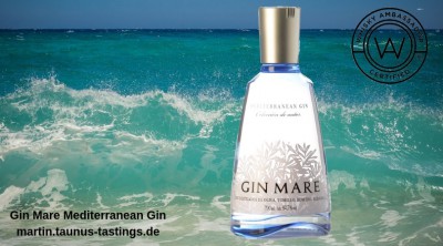 Eine Flasche Gin Mare Mediterranean Gin, im Hintergrund das Meer