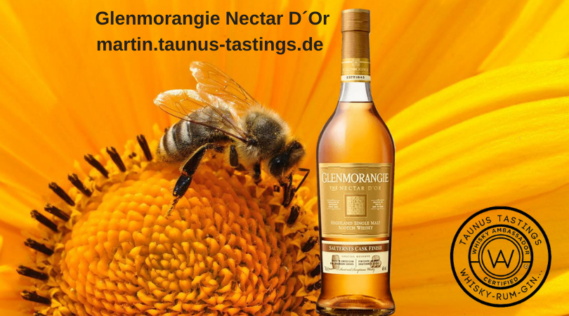 Eine Flasche Glenmorangie Nectar D´Or, im Hintergrund eine Biene auf einer Blume