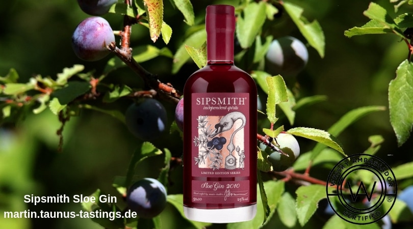 Eine Flasche Sipsmith Sloe Gin, im Hintergrund Wacholder