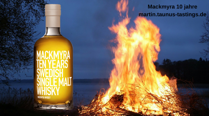 Eine Flasche Mackmyra 10 Jahre, im Hintergrund ein Lagerfeuer an einem See in Schweden