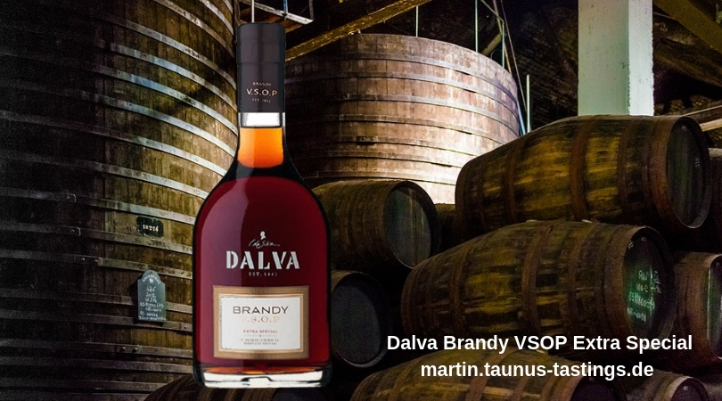 Eine Flasche Dalva Brandy VSOP Extra Special, im Hintergrund Fässer