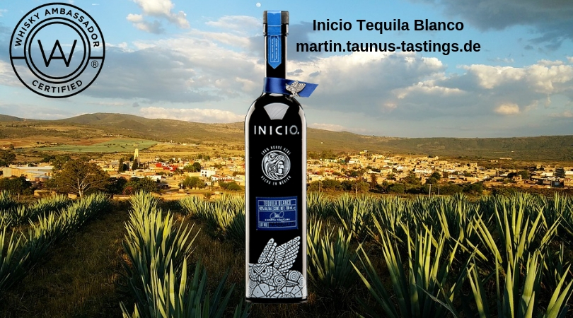 Eine Flasche Inicio Tequila Blanco, im Hintergrund eine Landschaft in Mexico