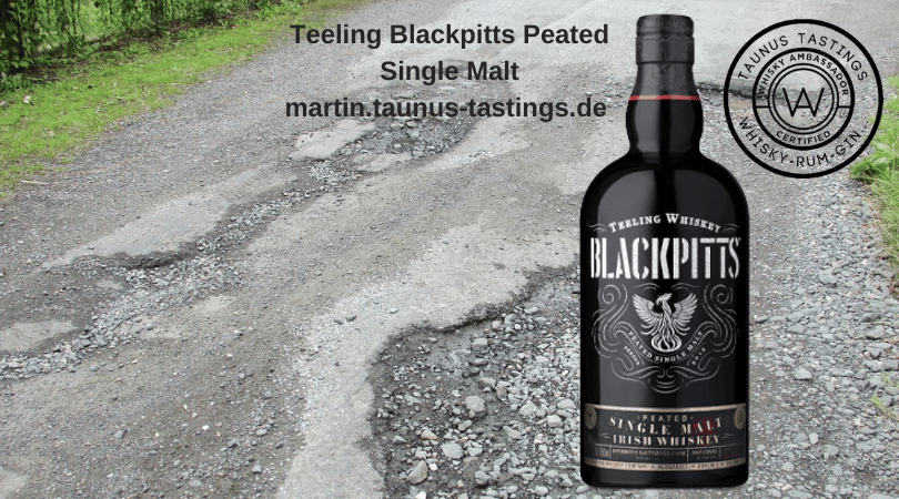 Eine Flasche Teeling Blackpitts Peated Single Malt, im Hinergrund eine Straße mit Schlaglöchern