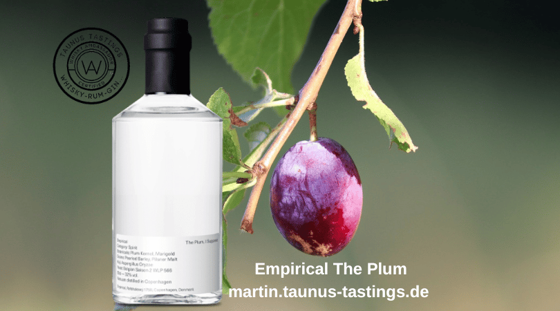 Eine Flasche Empirical The Plum, im Hintergrund eine Pflaume