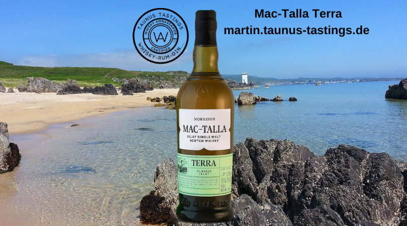 Eine Flasche Mac-Talla Terra, im Hintergrund ein Küstenabschnitt auf der Insel Islay, Schottland