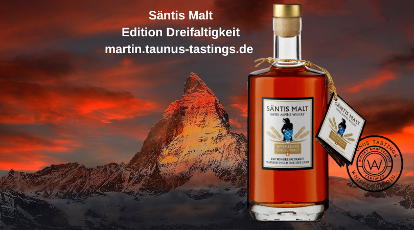 Eine Flasche Säntis Malt Edition Dreifaltigkeit, im Hintergrund ein Berggipfel in der Schweiz