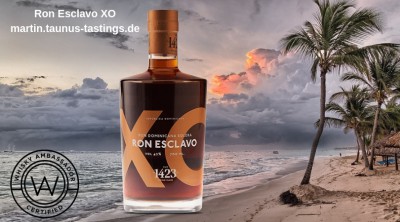 Eine Flasche Ron Esclavo XO, im Hintergrund eisn Strand auf der Dom. Rep.