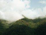 green mountains with thick white clouds