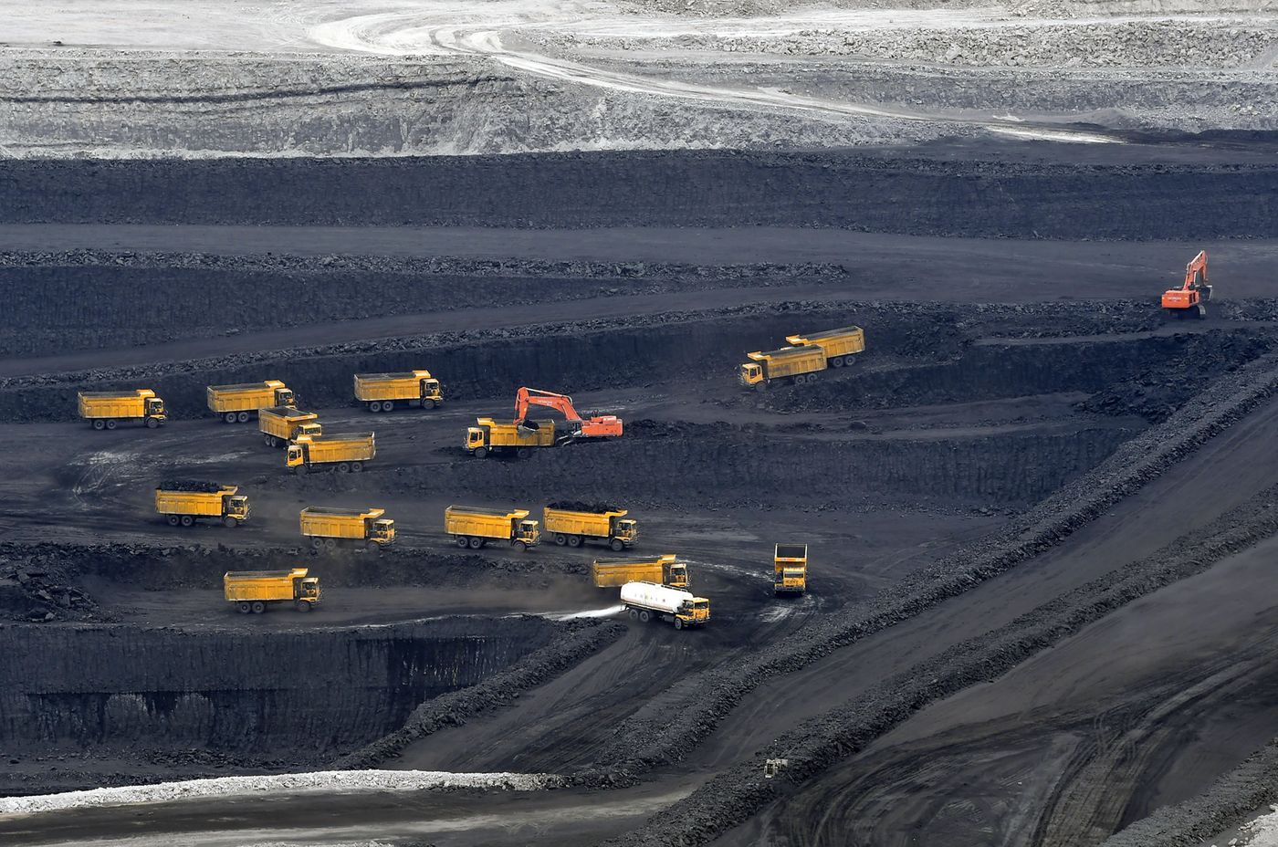 Transport trucks transfer raw coal in pits in Changji Hui Autonomous Prefecture.