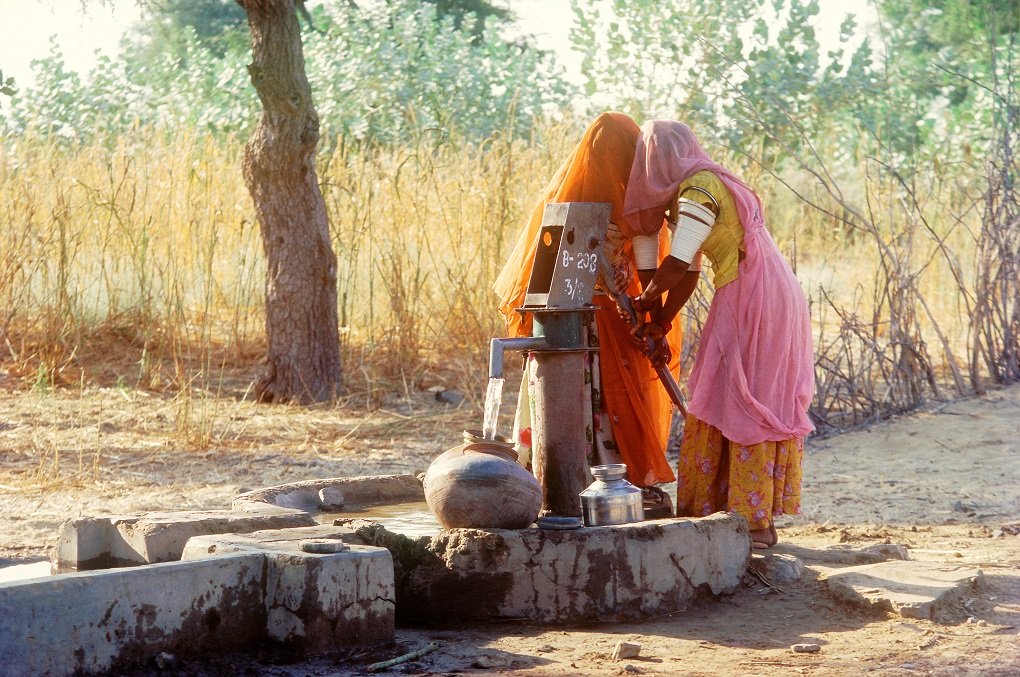 Women drawing water from a hand pump in Rajasthan