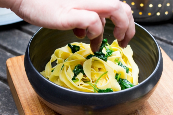 Voeg de champignons en de fijngehakte walnoten toe bij de pasta