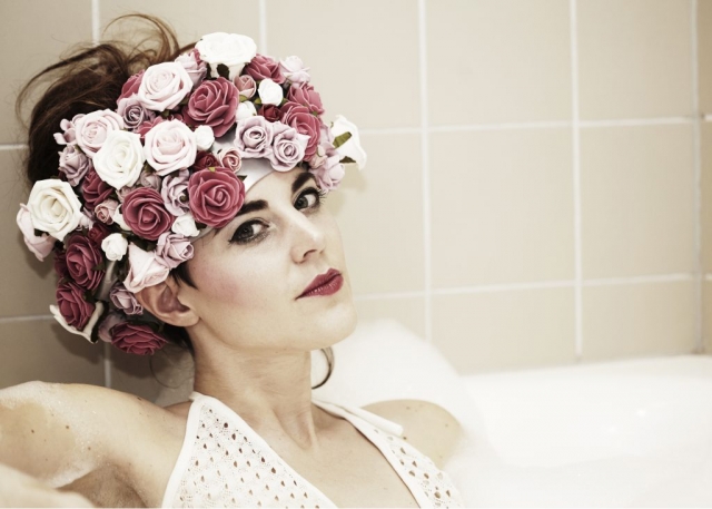 Model in bath with roses on her head