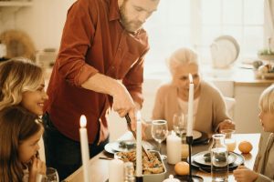 Deck the Halls (and the Kitchen)! A Real-Life Mallorcan Holiday Tale 13 A warm family gathering around a festive Thanksgiving dinner table with candles and smiles.