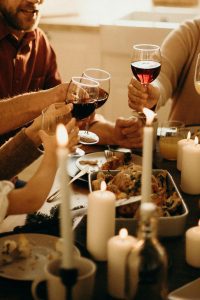Deck the Halls (and the Kitchen)! A Real-Life Mallorcan Holiday Tale 17 Warm family dinner scene with wine toasting and candlelight ambiance for a festive celebration.