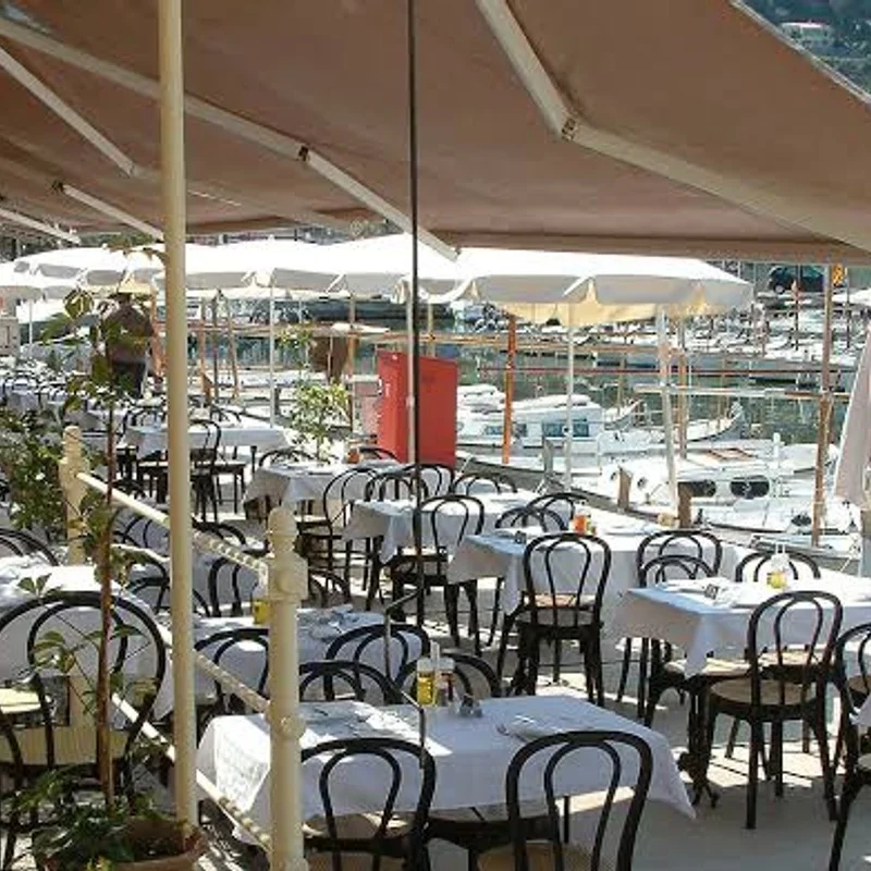 Terraza del restaurante Mar y Sol en Sóller con mesas preparadas frente al puerto y barcos atracados