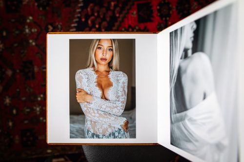 Fotobok med boudoirbilder på en blond kvinna i vit spetsklänning