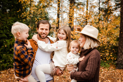 Familjefotografering i Småland på hösten med en glad och busig familj utomhus.