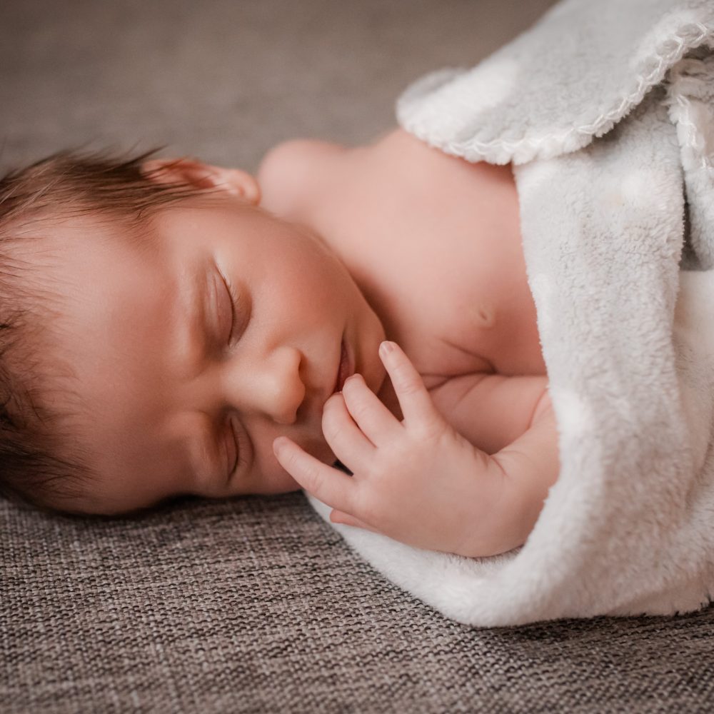 Nyfödd bebis sover lugnt under nyföddfotograferingen