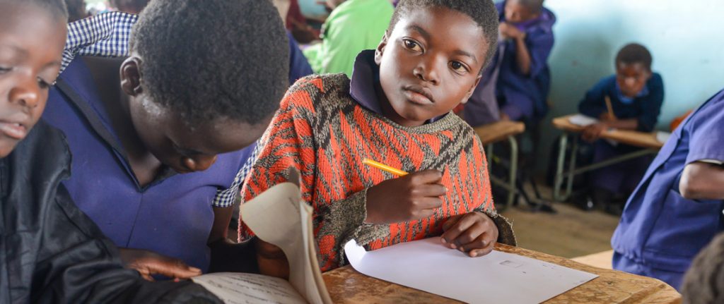 Three young girls in their classroom.