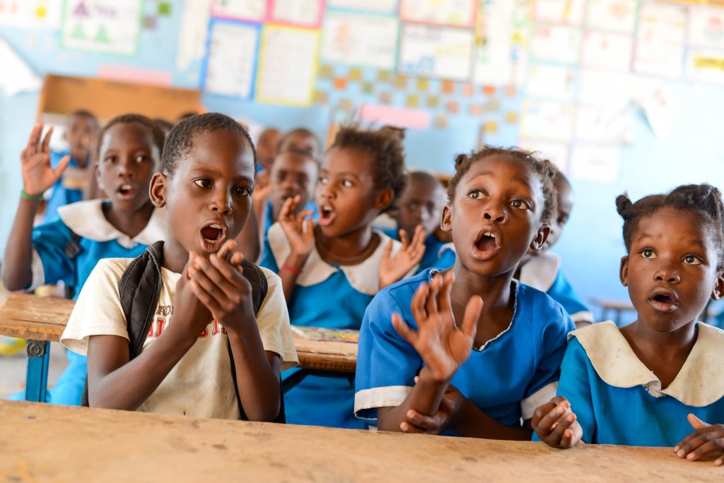 A boy named Davies singing a song with his classmates at school.