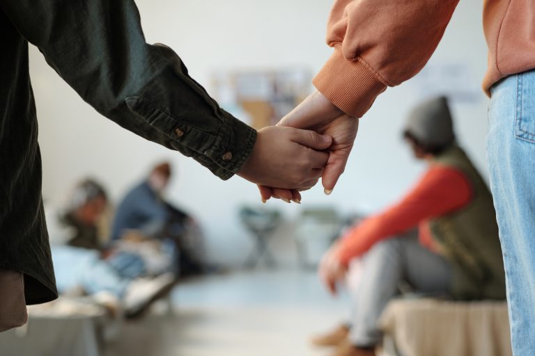 A woman holding a child's hand in a shelter.