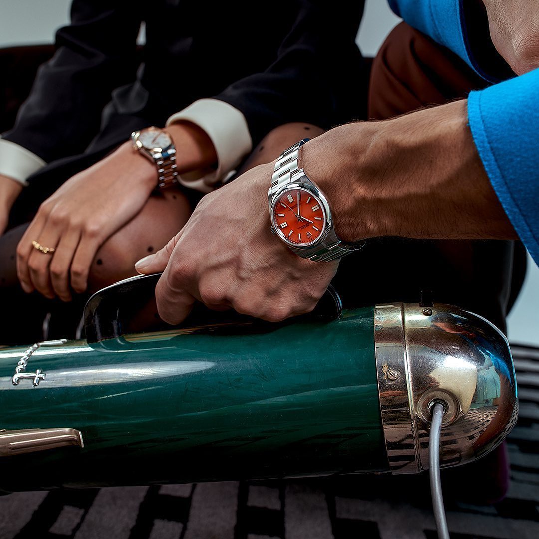 Close-up on the hand of a man wearing a Rolex and vacuuming