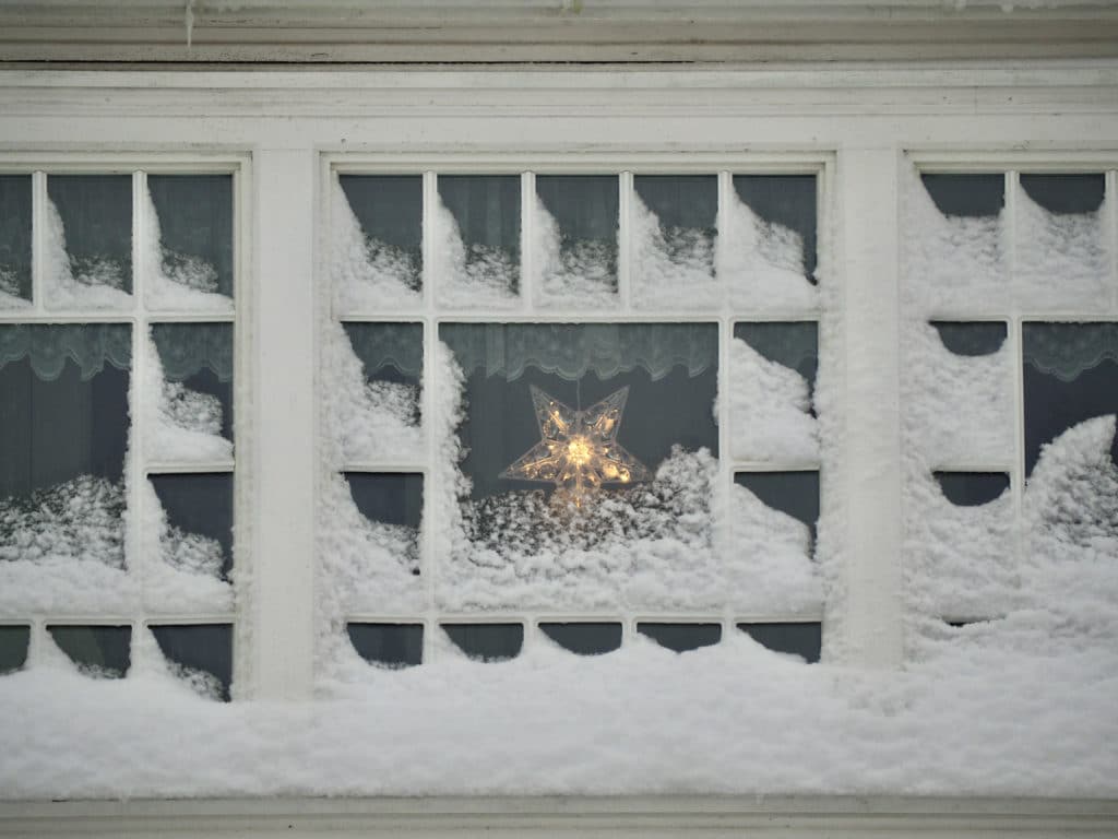 stjerna lyser i ett nedsnødd vindu