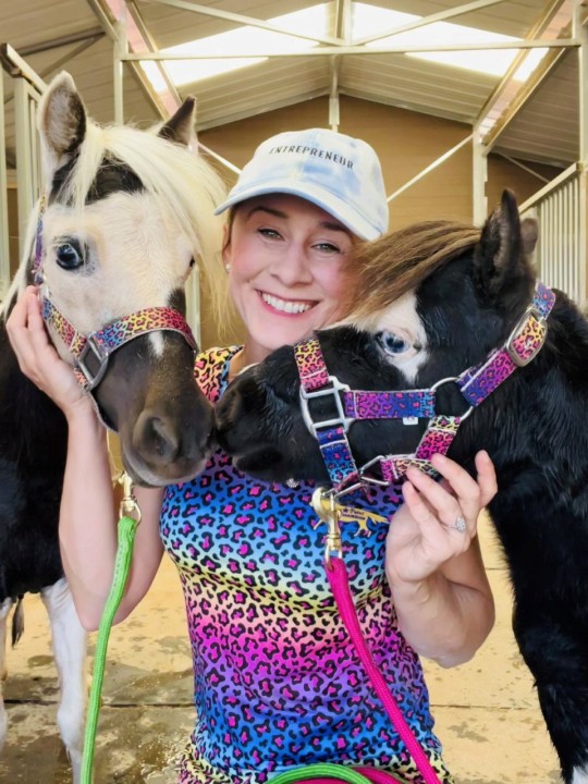 Lana Grieve who makes clothes so that miniature horses and their owners can match. See SWNS story SWSMhorse. A woman said she found a huge gap in the market...matching outfits suited to miniature horses and their owners. Lana Grieve, 34, owns six horses - five of them miniatures, and used to just sell horse blankets. But she soon branched out to creating matching human riding clothes - such as leggings, t-shirts, sweatshirts, hats and accessories - so owners can match their pets. She loves to showcase her own gear - by dancing around modelling them with her tiny horses - and has a wardrobe stuffed with matching outfits.