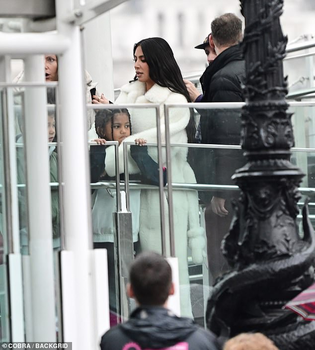 Doting mum: Kim kept Saint warm as they waited to board the pod