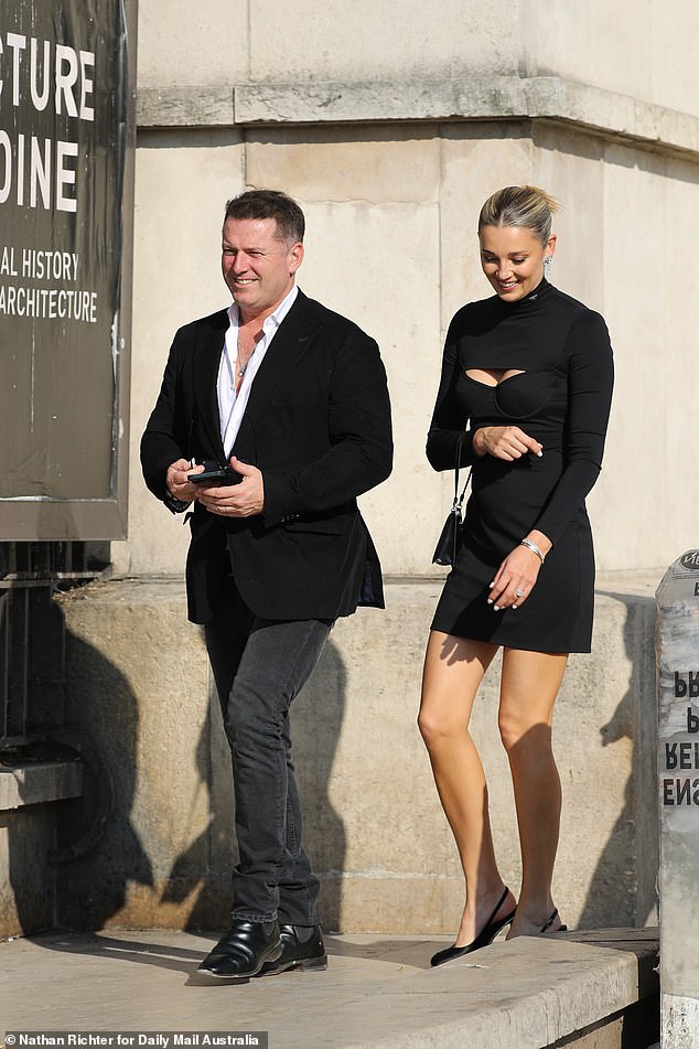 Karl wore a sleek black blazer, matching skinny jeans and a collared shirt worn half unbuttoned