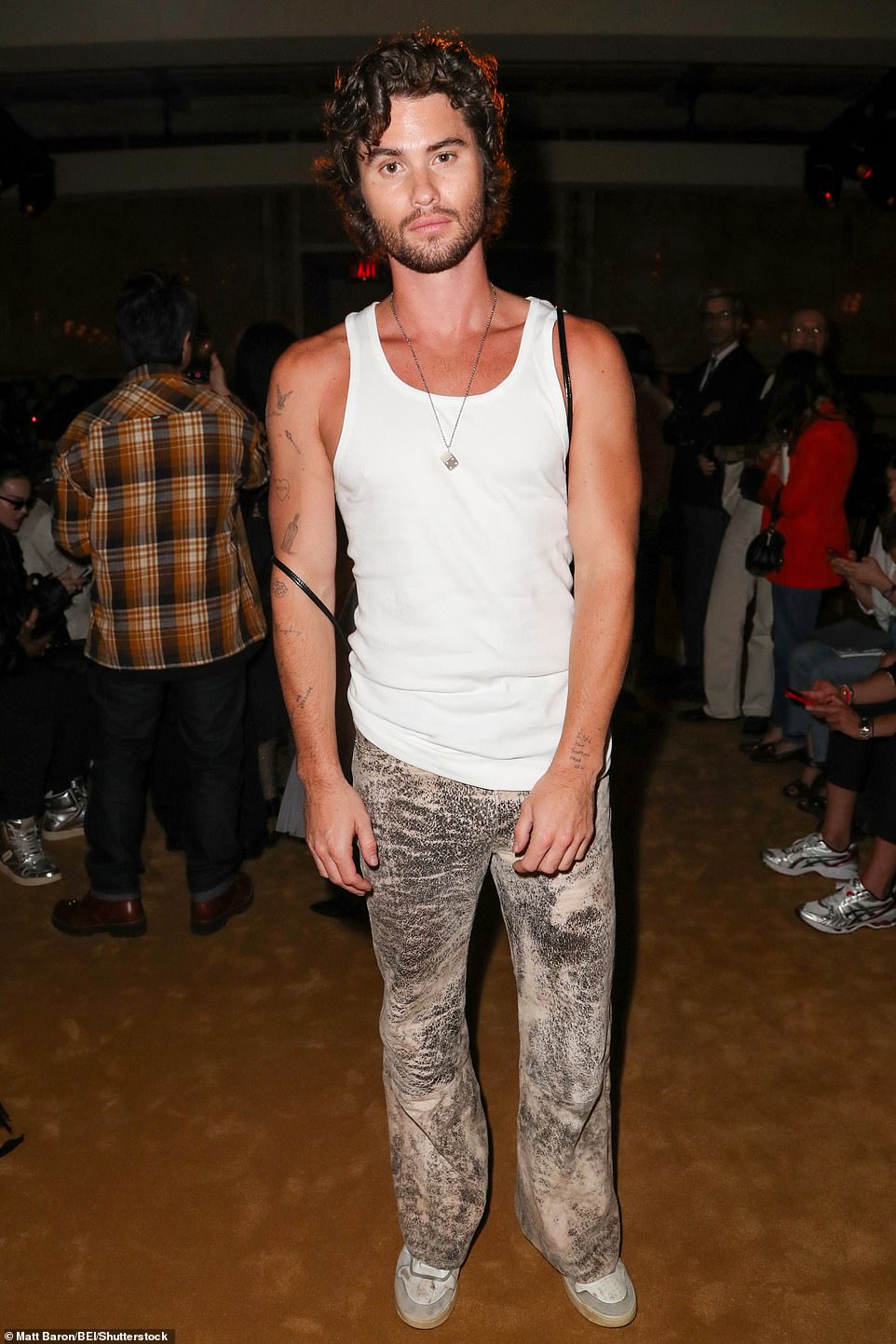 Hunk: Chase Stokes ¿ who is dating country songstress Kelsea Ballerini ¿ looked muscular in a white tank top styled with unique flared pants and worn-in sneakers