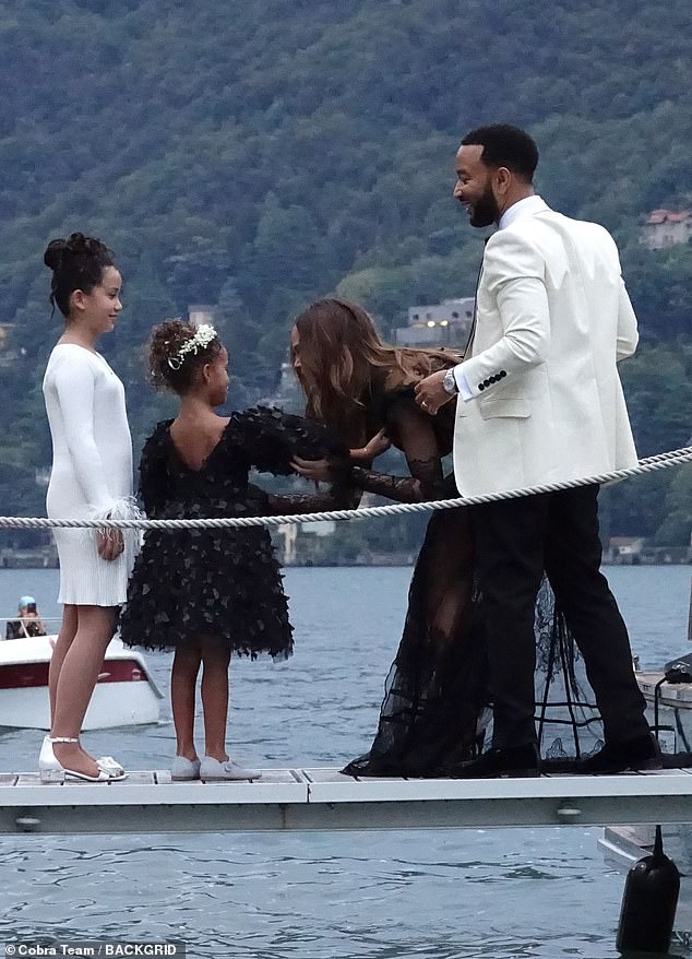 Lake life: The mother of four looked stunning in a floor-grazing black dress with long sleeves and sheer patches throughout the sleeves, torso and skirt