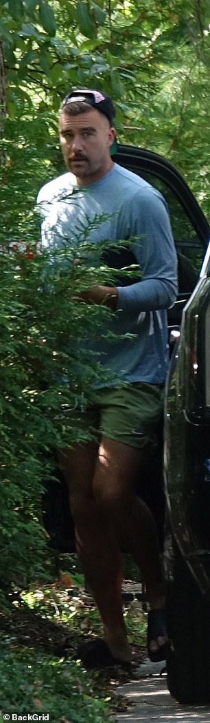 The NFL star arrived in slides with a backwards baseball cap over his short locks