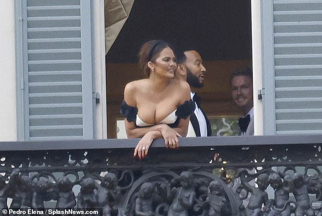 Balcony: She wore her hair in an updo with a black headband and wore diamond drop earrings as they exchanged vows and later posed on a balcony like a royal couple