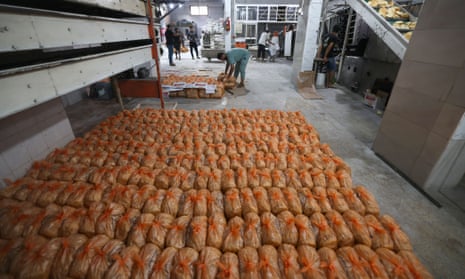 Bakery staff prepare bread packages as to cater for Palestinians queueing outside in Rafah in the southern Gaza Strip on 18 October 2023.