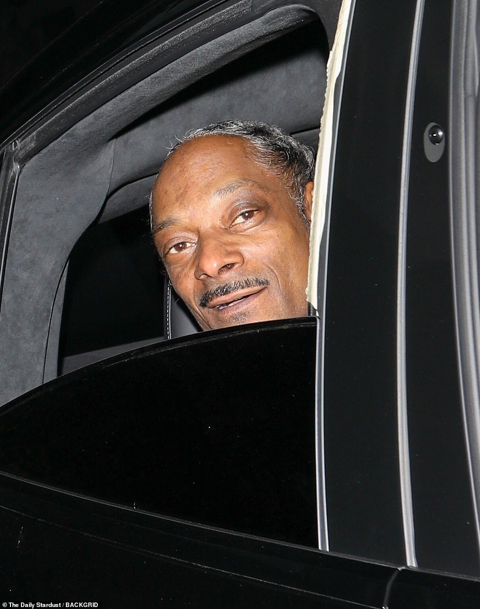 Arrival: Snoop Dogg, 52, was seen arriving in a black SUV as he stuck his head out of the backseat window
