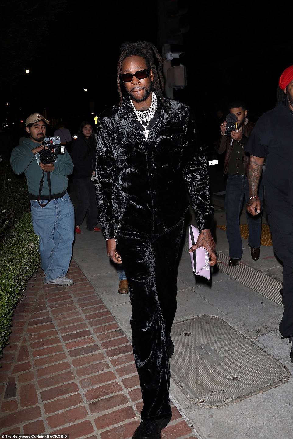 Flawless: Rapper 2 Chainz looked impeccable in a loose-fitting, casual black velvet suit teamed with black footwear